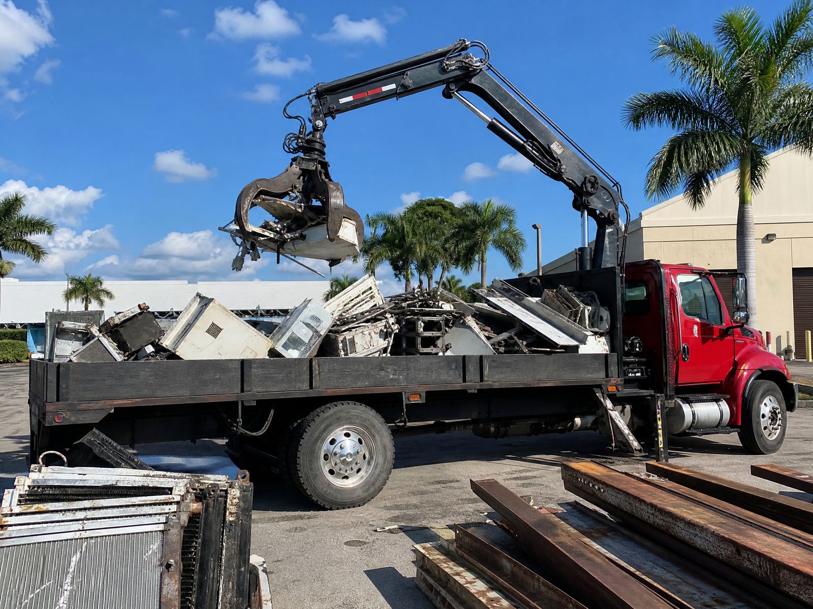 Scrap metal pickup truck loading at a commercial site in Florida
